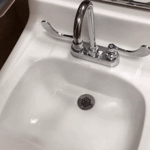 A sink next to an motion sensing paper towel dispenser, arranged so that turning on the faucet automatically activates the dispenser. Titled "when you write 2 unit tests and no integration tests".